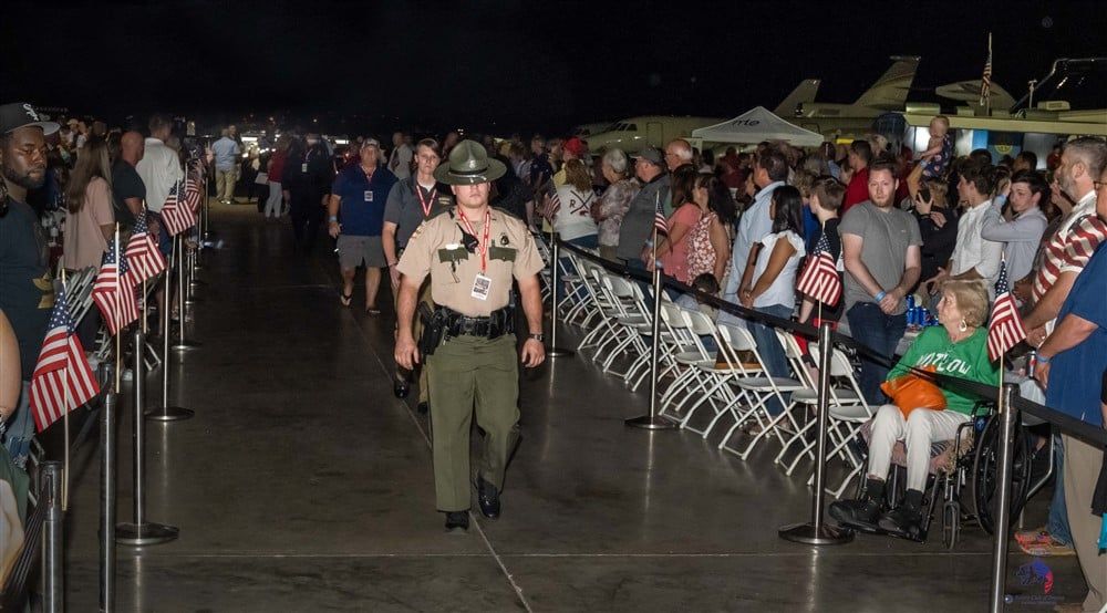 A police officer is walking through a crowd of people.