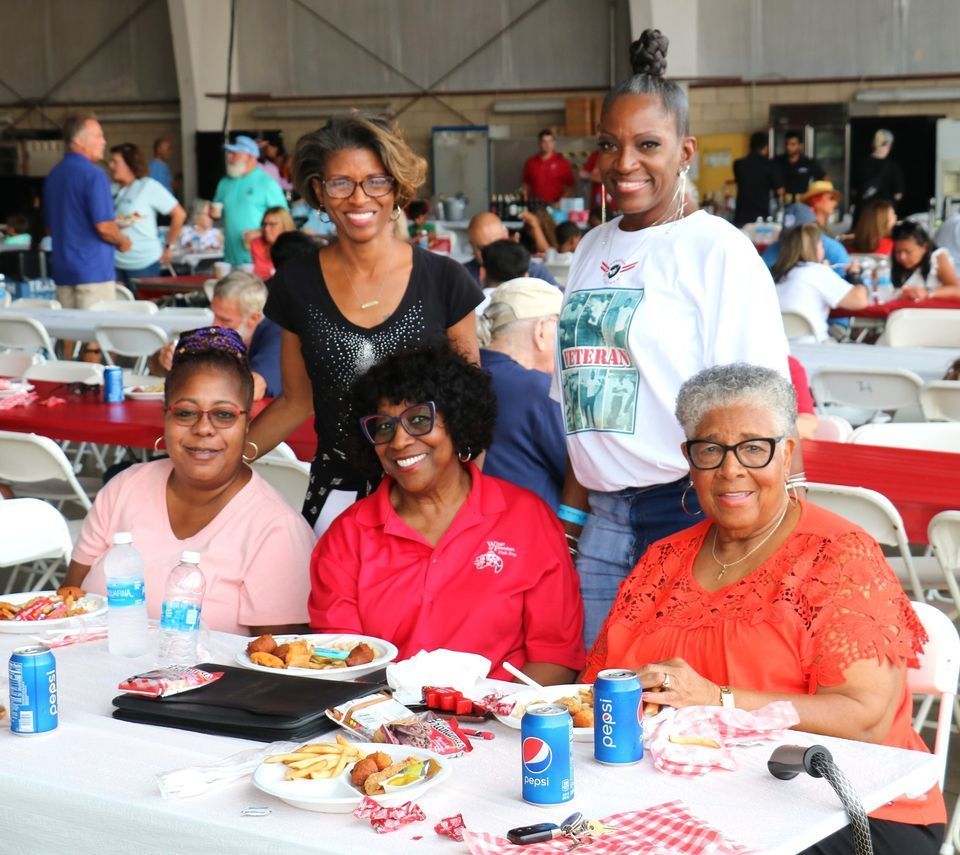 A group of women sitting at a table with pepsi cans