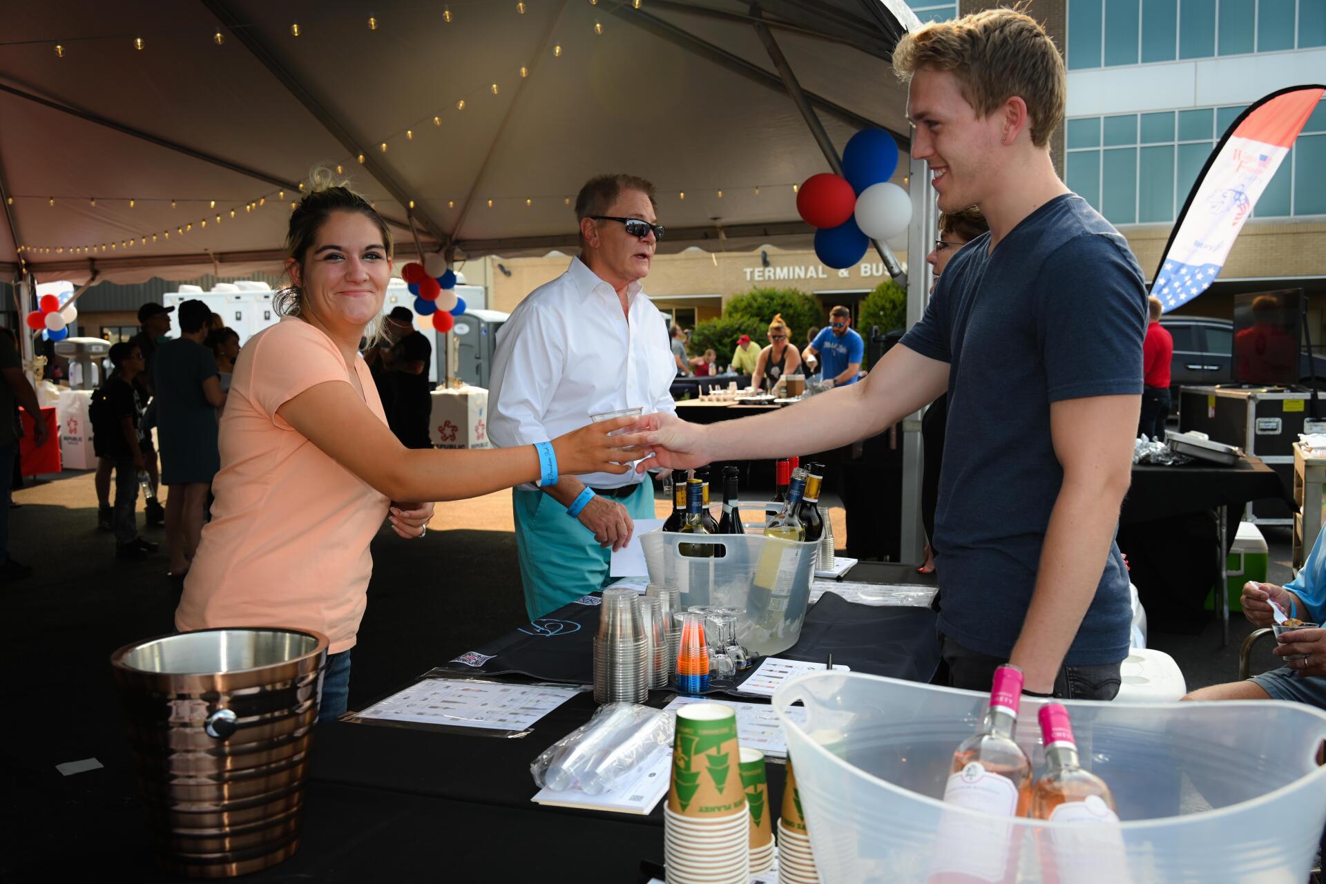 A man and a woman are shaking hands at a table.