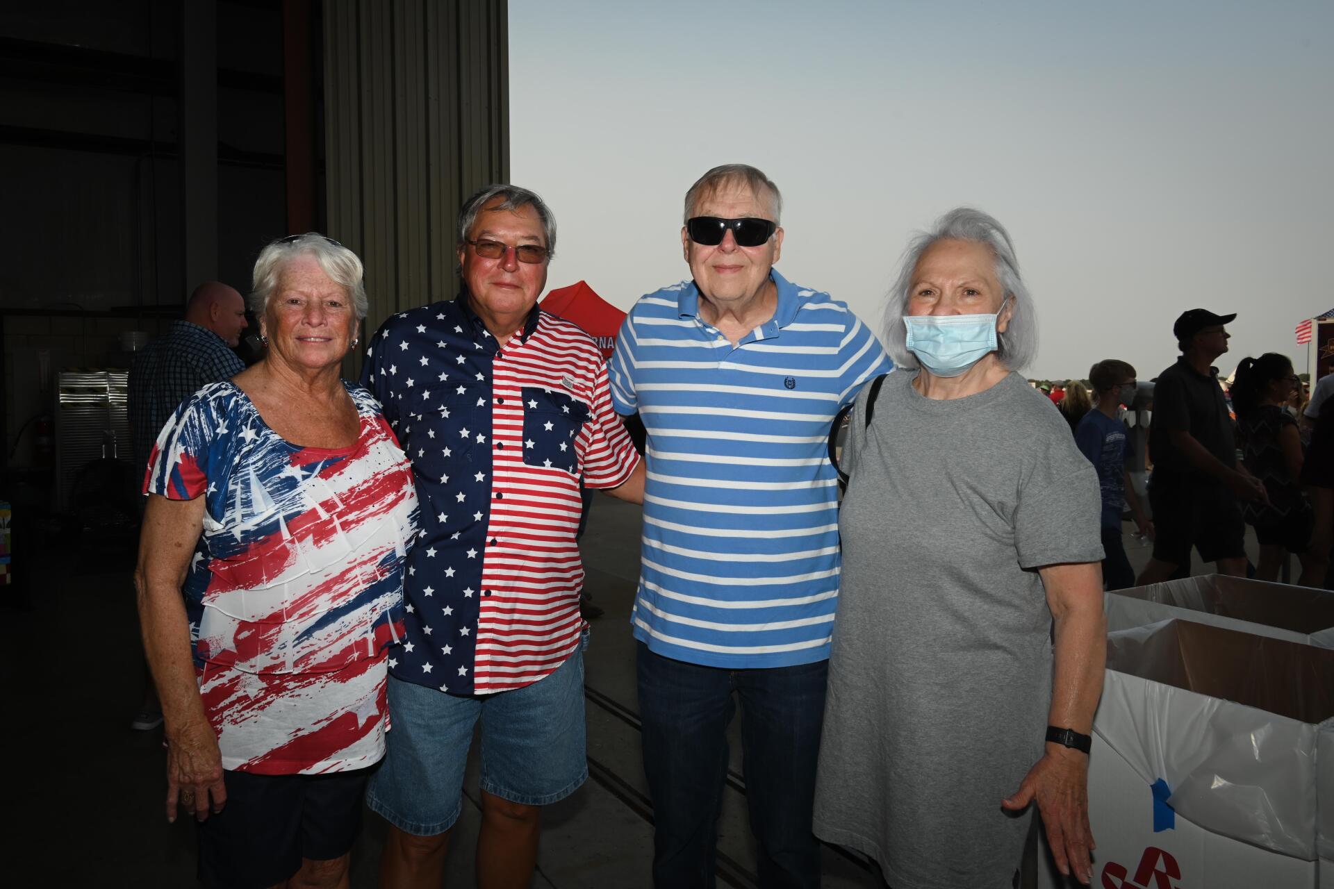 A group of people wearing face masks are posing for a picture.