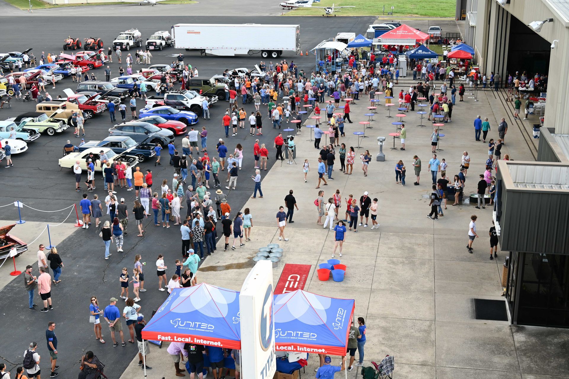 A large crowd of people are gathered in a parking lot