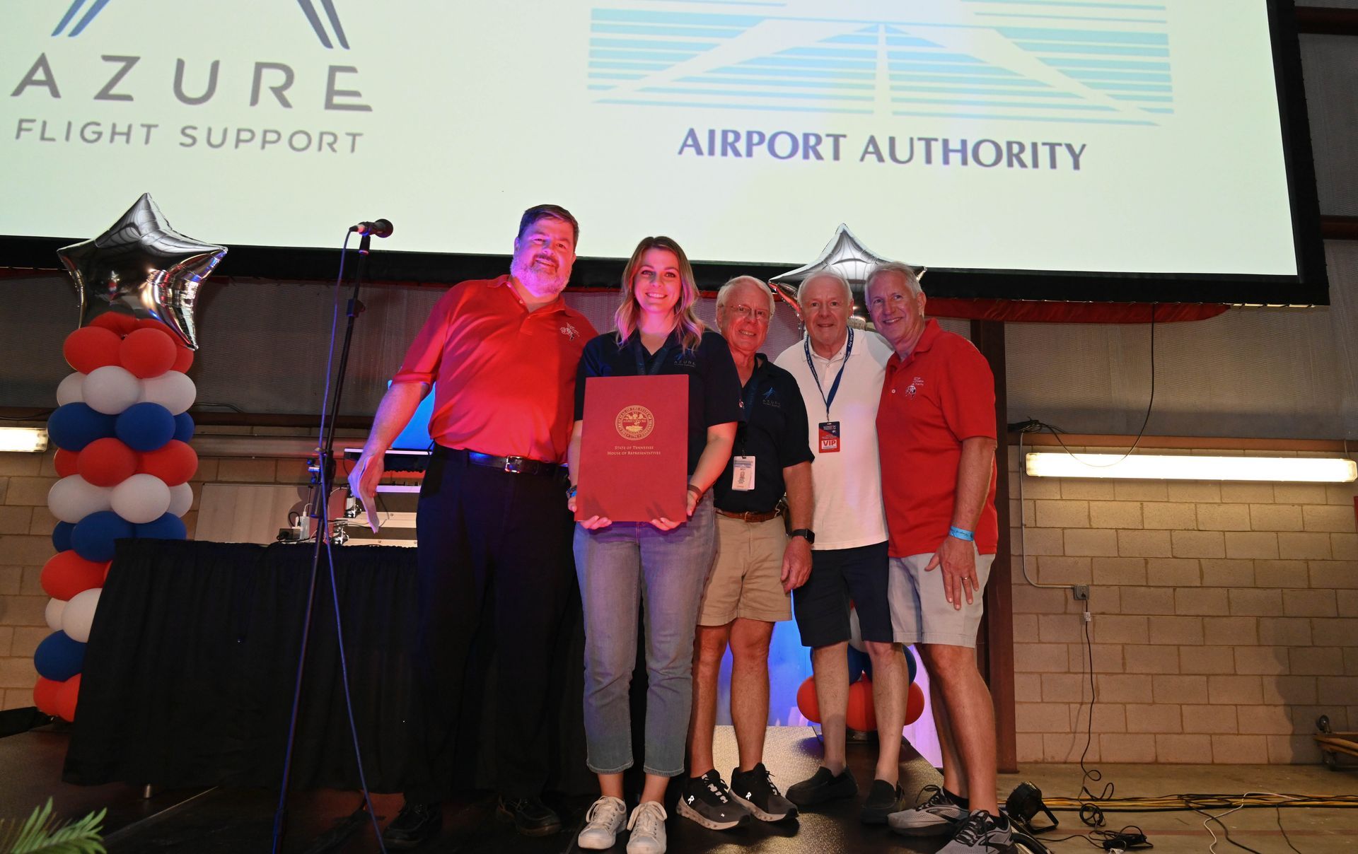 A group of people standing in front of an airport authority sign