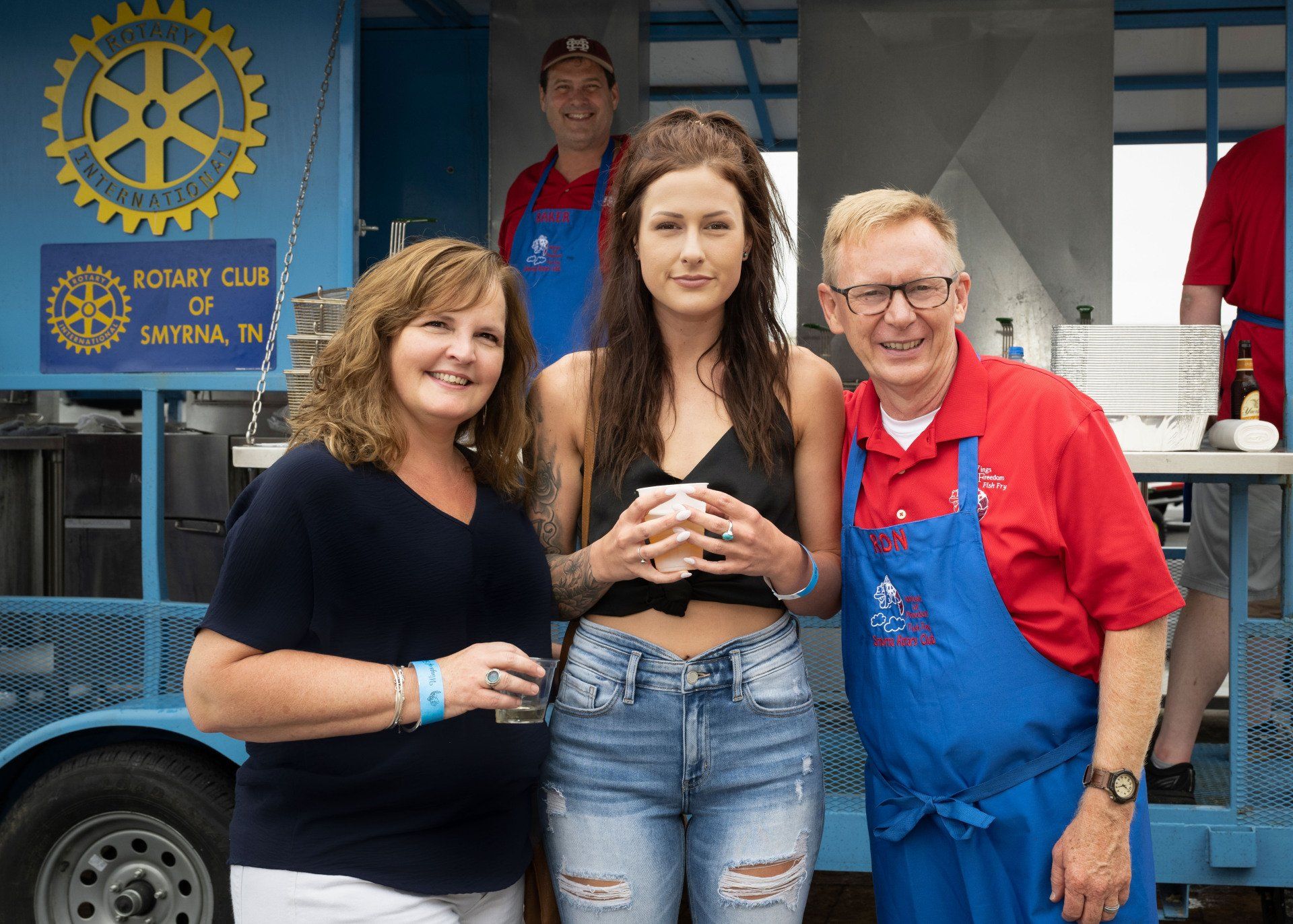 A group of people are posing for a picture in front of a food truck.