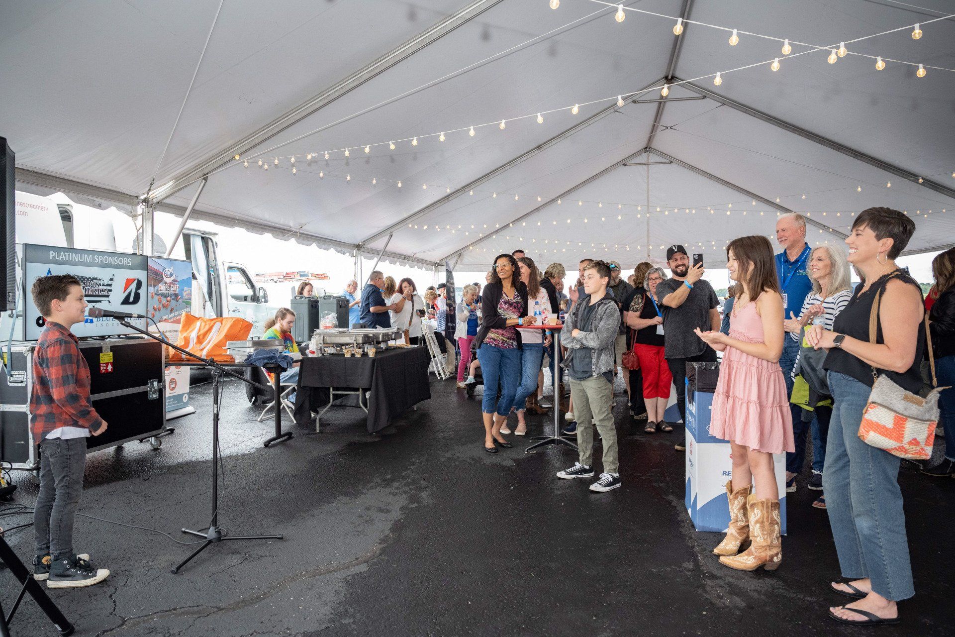 A group of people are standing under a tent.