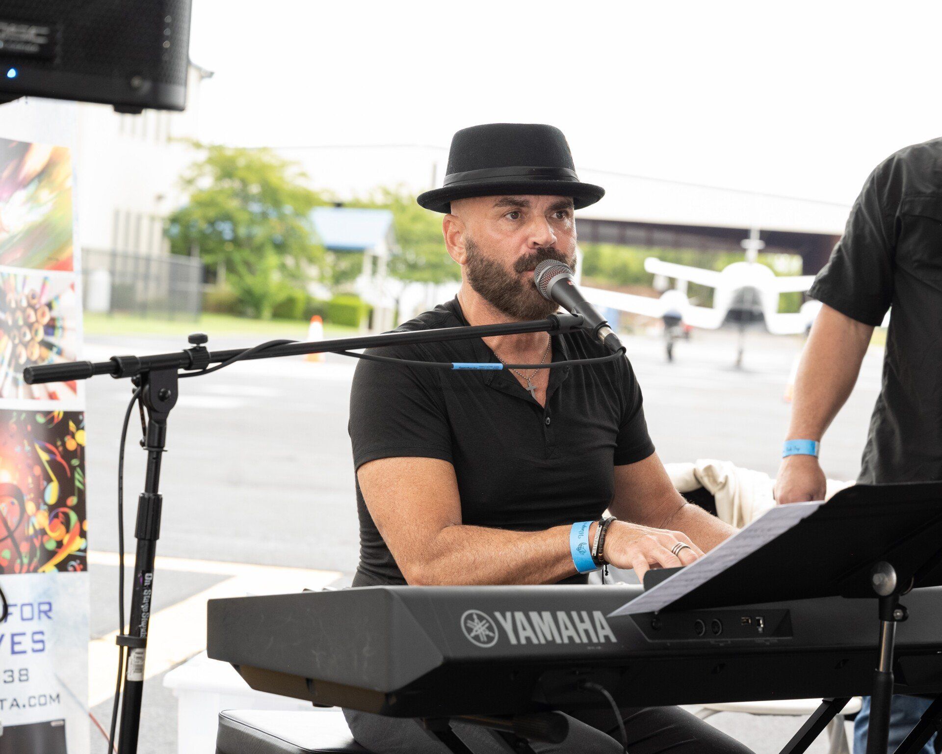 A man is playing a keyboard and singing into a microphone.