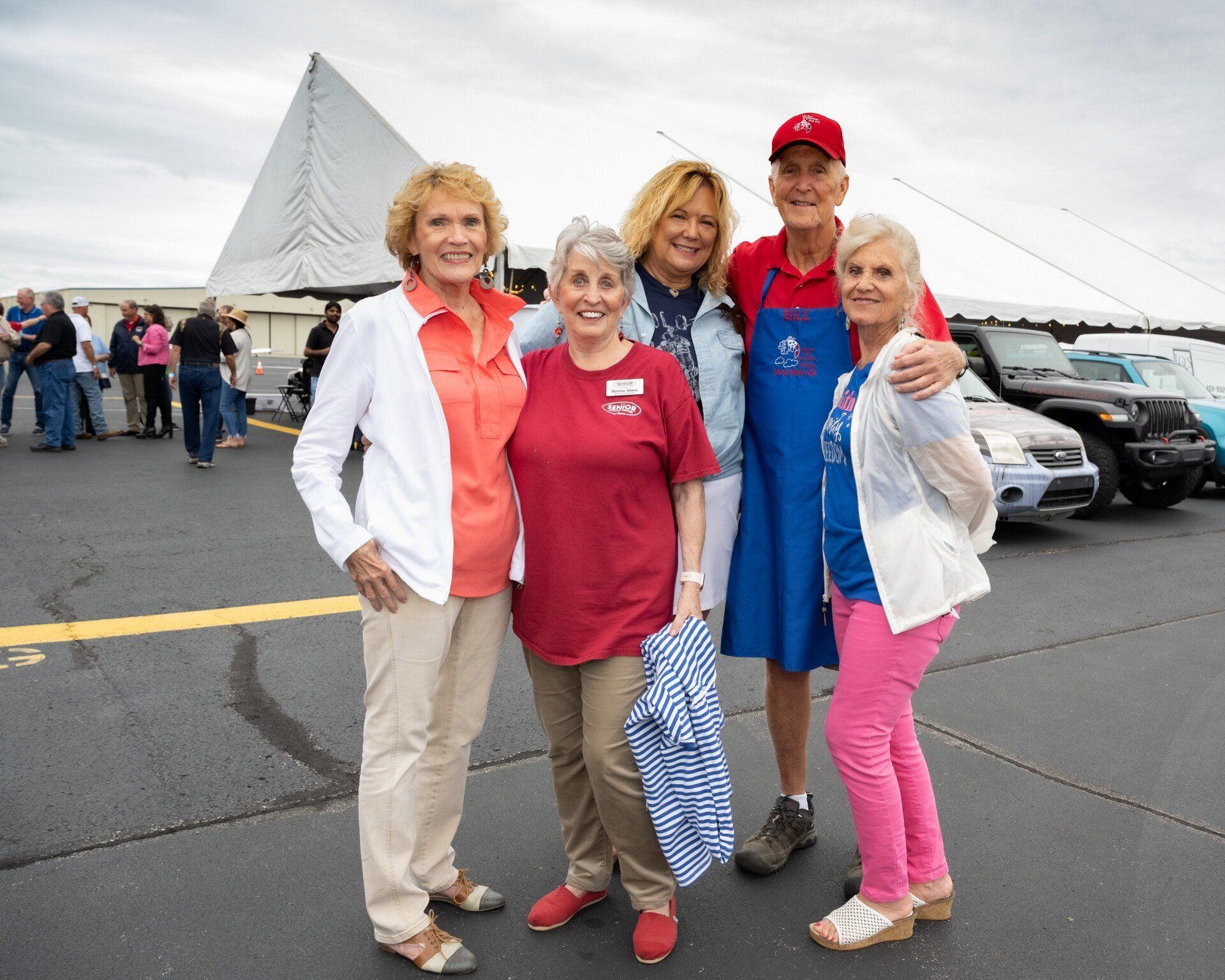 A group of people posing for a picture in a parking lot