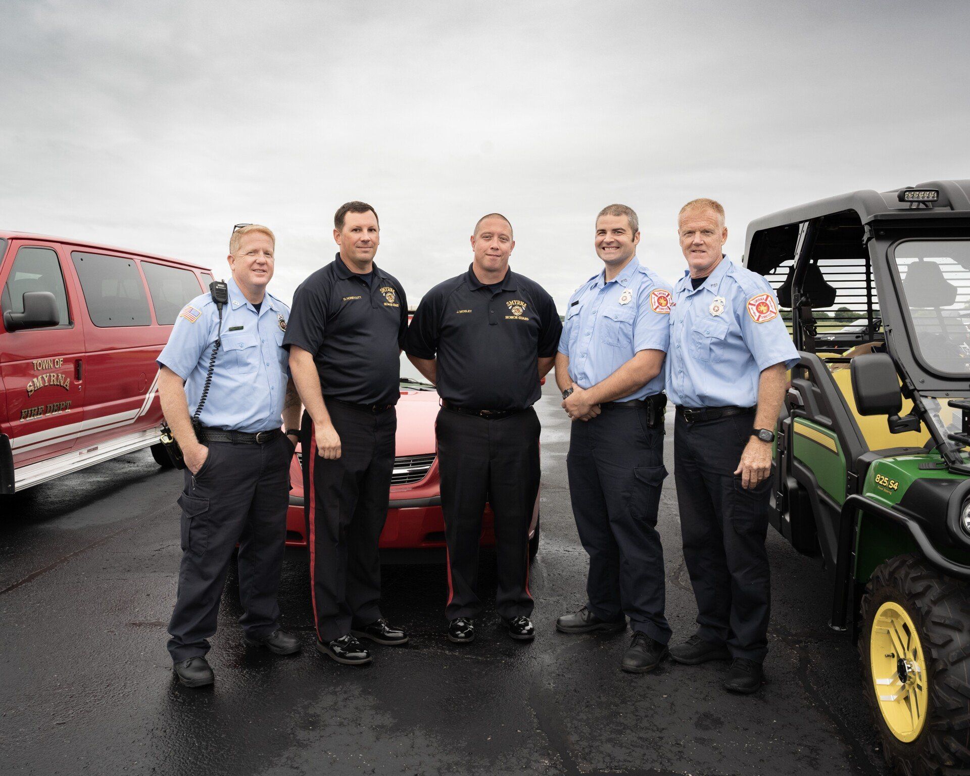 A group of men are standing next to each other in a parking lot.