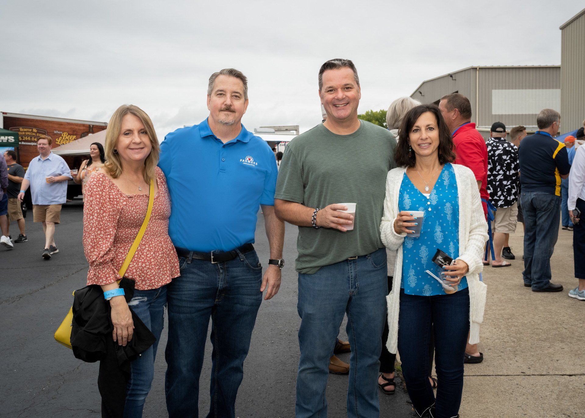 A group of people are posing for a picture in a parking lot.