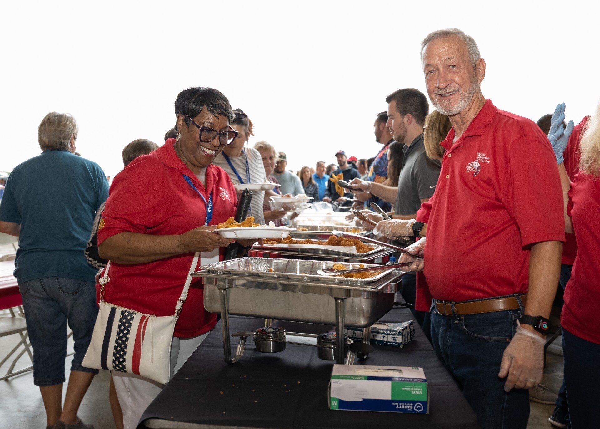 A group of people are standing around a buffet table.