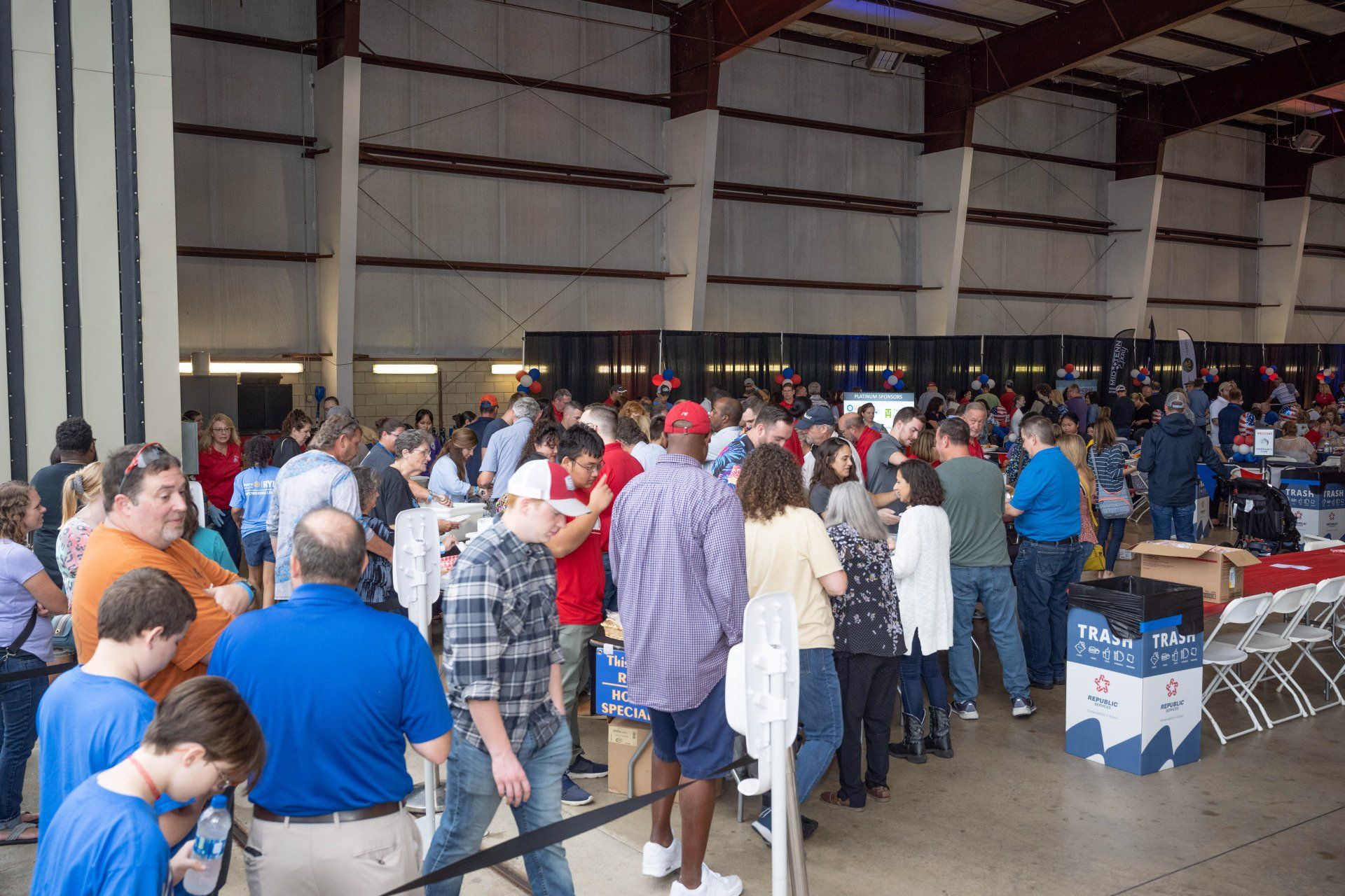 A large group of people are standing in a warehouse.