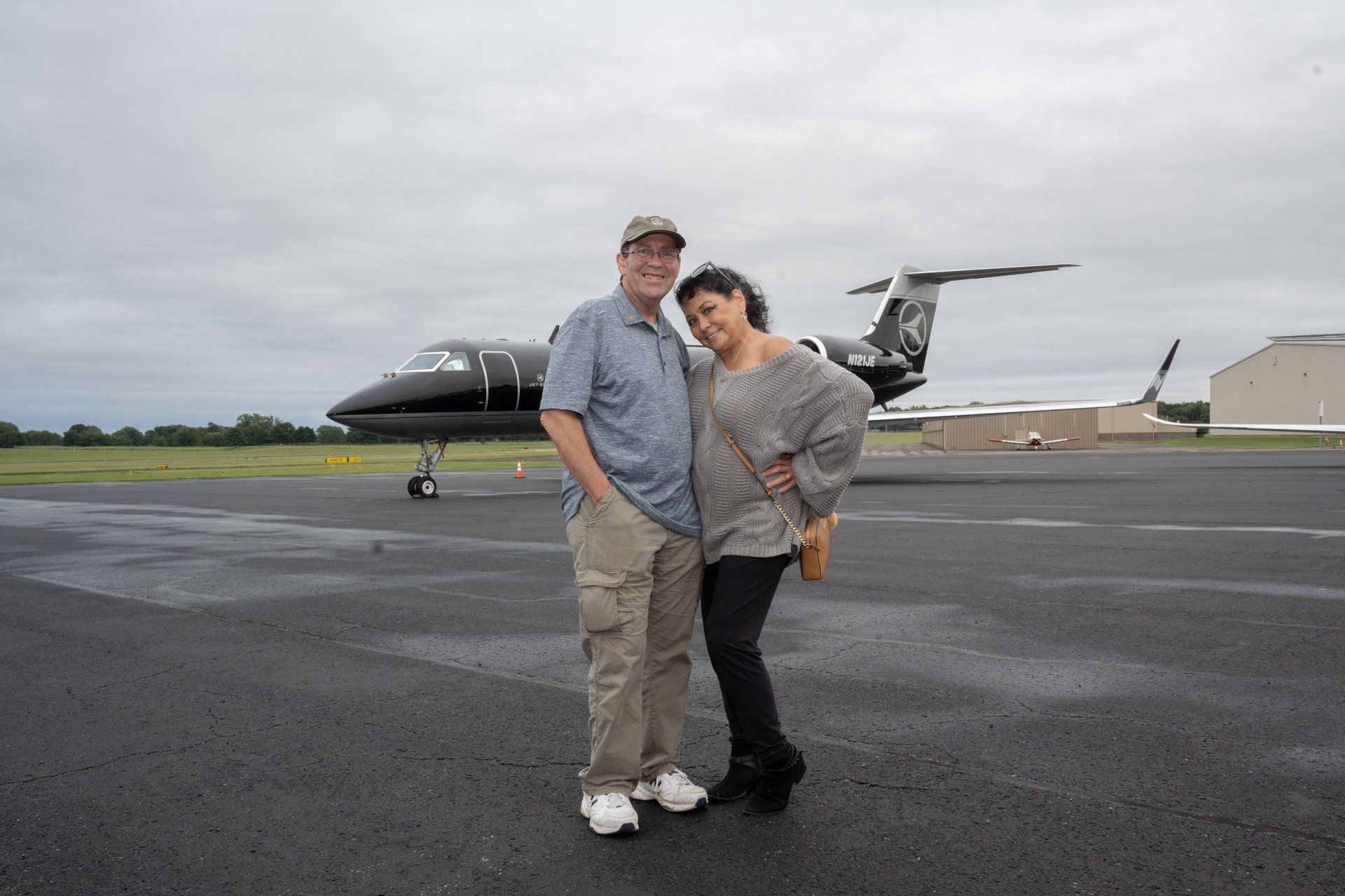 A man and woman standing in front of an airplane