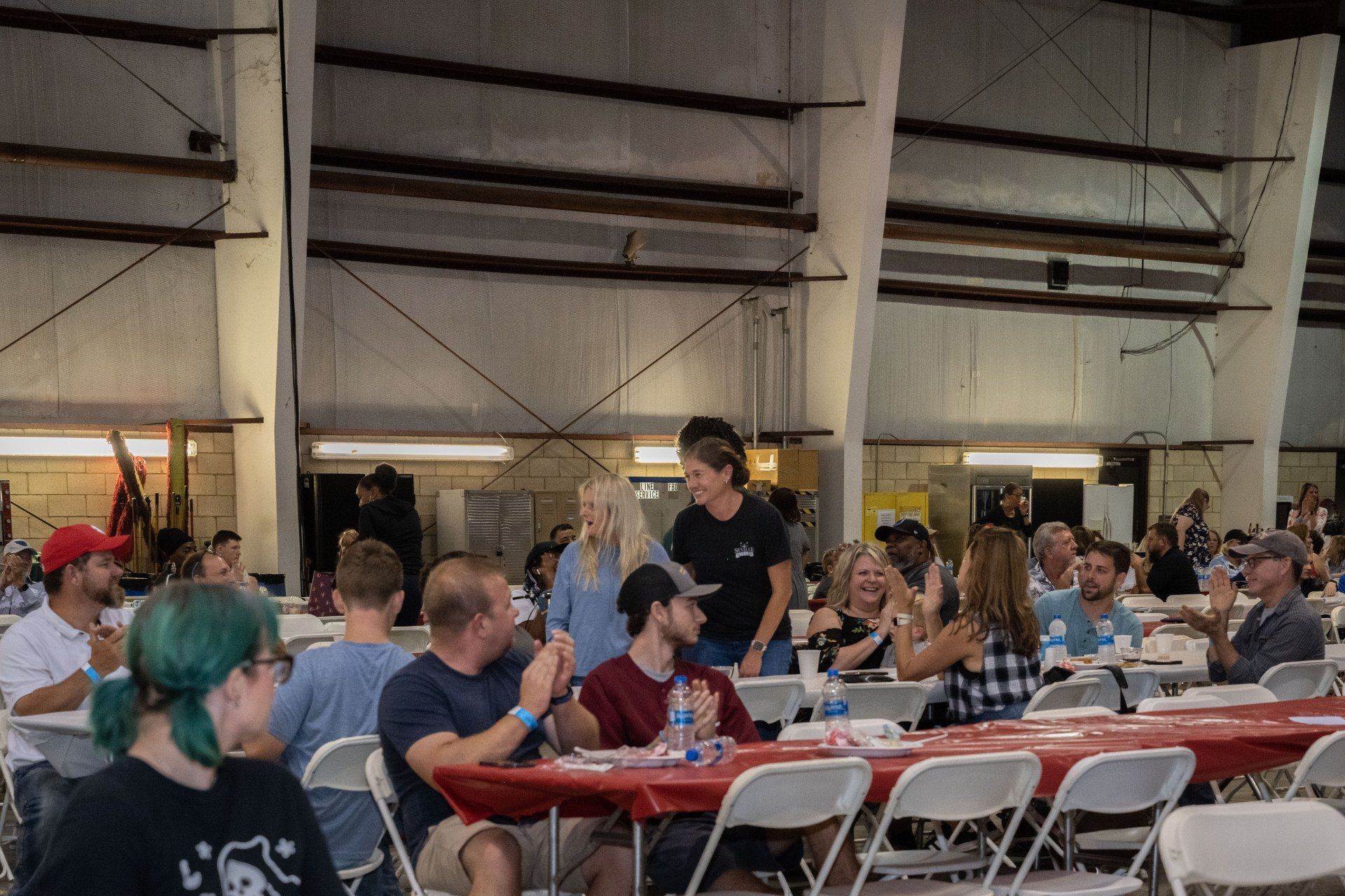 A group of people are sitting at tables in a large room.