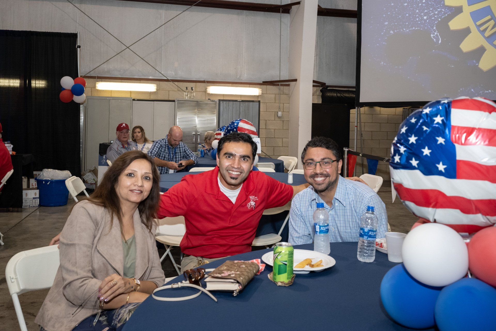A group of people are sitting at a table with balloons.