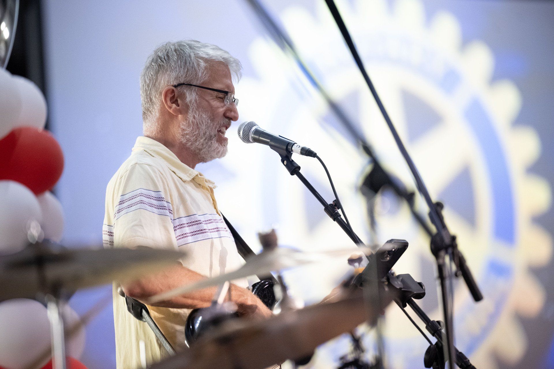 A man with a beard is singing into a microphone