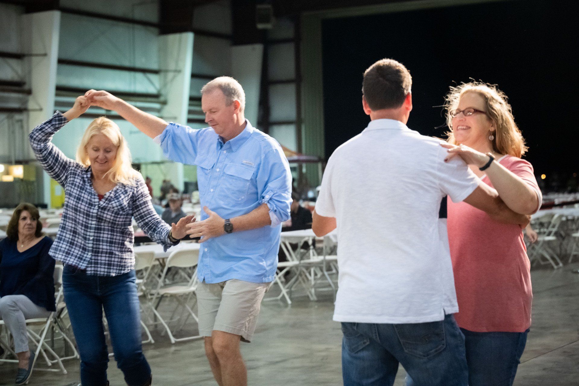 A group of people are dancing together in a room.