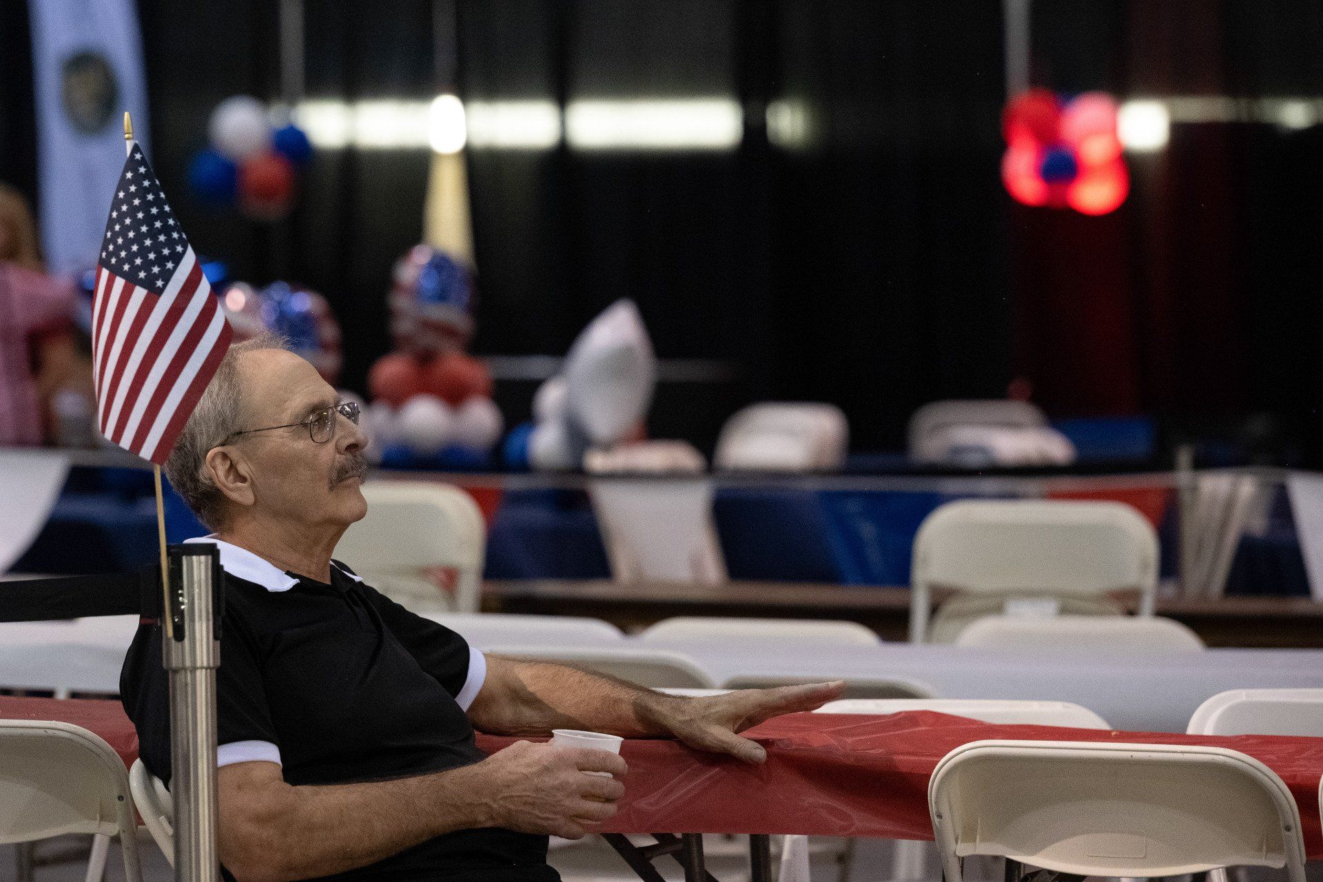 A man is sitting at a table with an american flag on it.