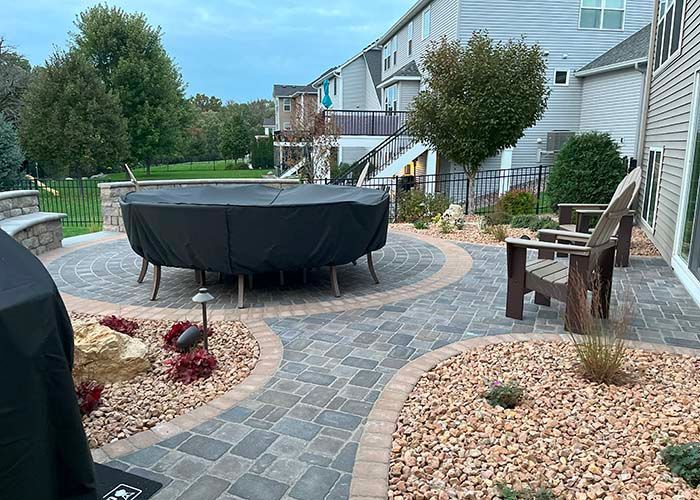 A patio with a table and chairs and a grill.