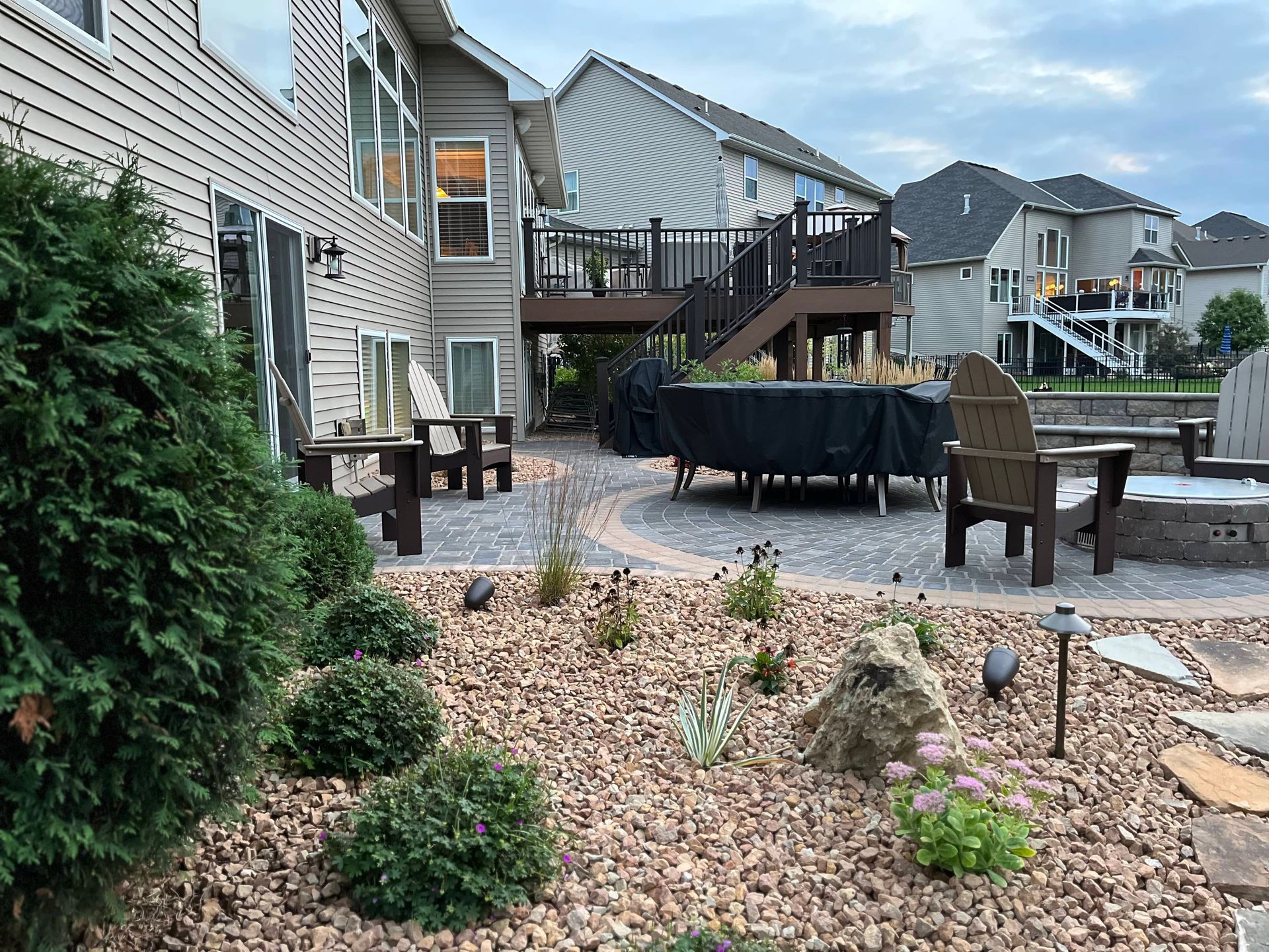 A patio with a table and chairs in front of a house.