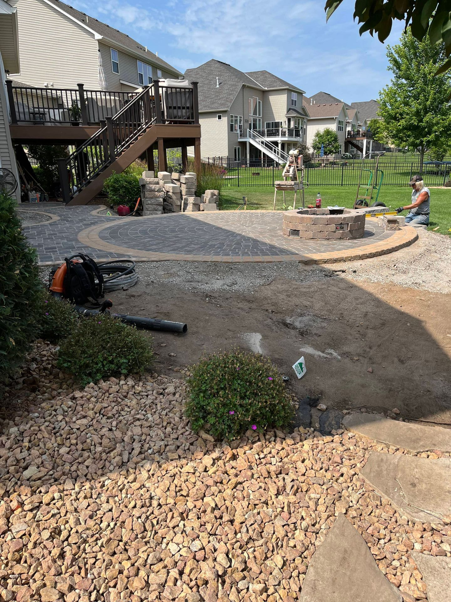 A fire pit is being built in the backyard of a house.