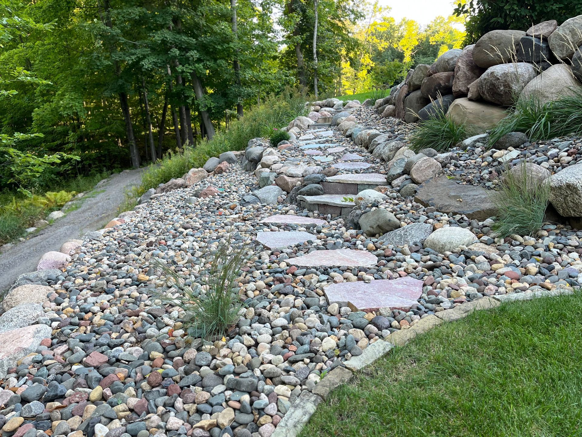 A path made of rocks and steps leading to a forest.
