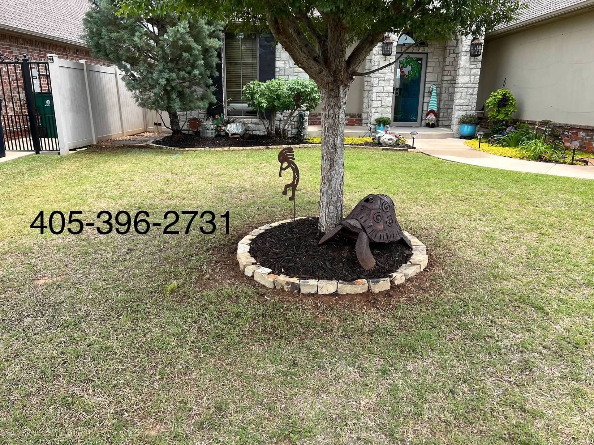 Front yard with a small tree in a circular stone bed and a lawn; phone number 405-396-2731 visible.