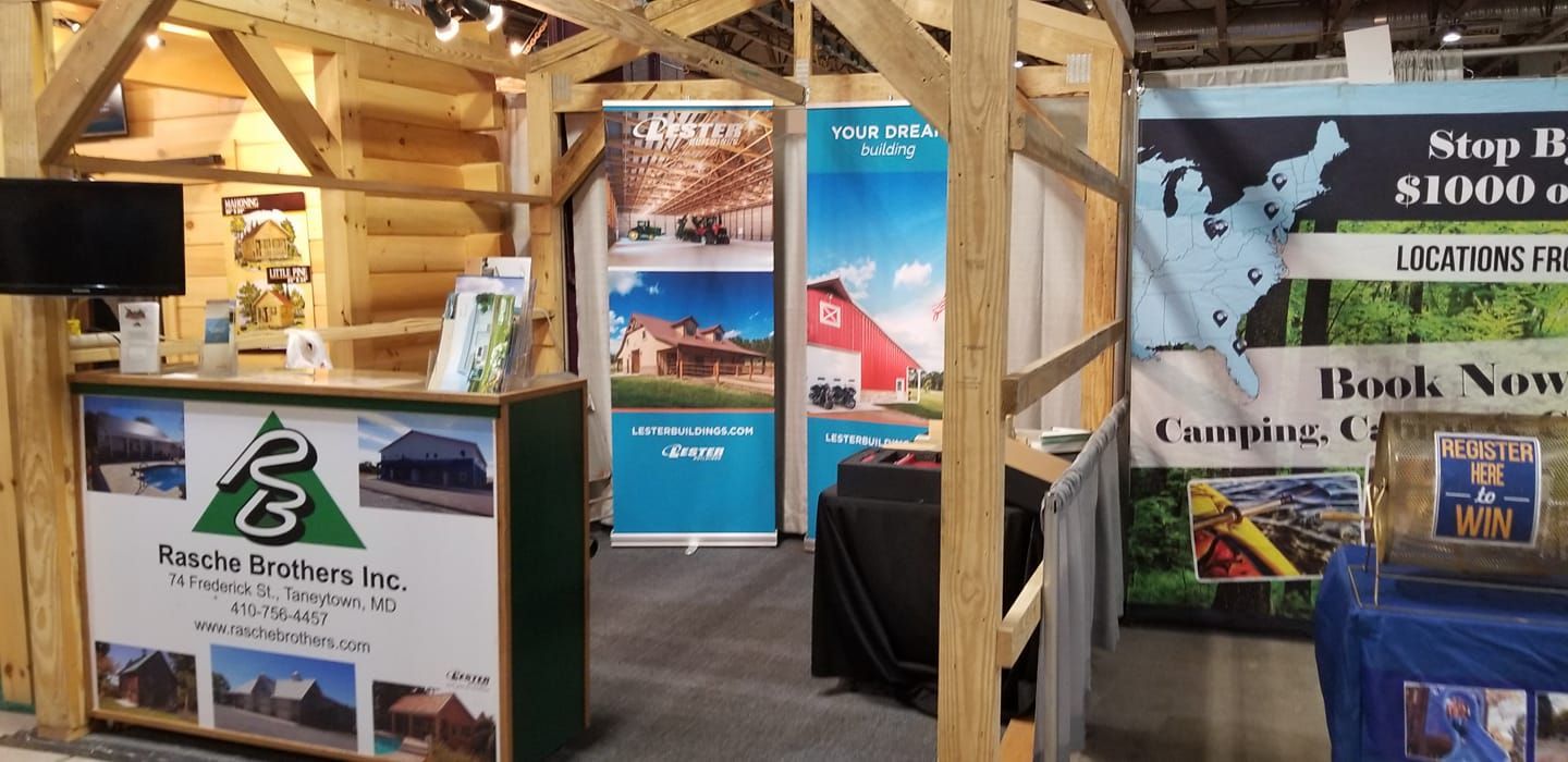 A trade show booth for Reinke Brothers Inc. features a rustic wooden frame, informational banners, and a display desk.