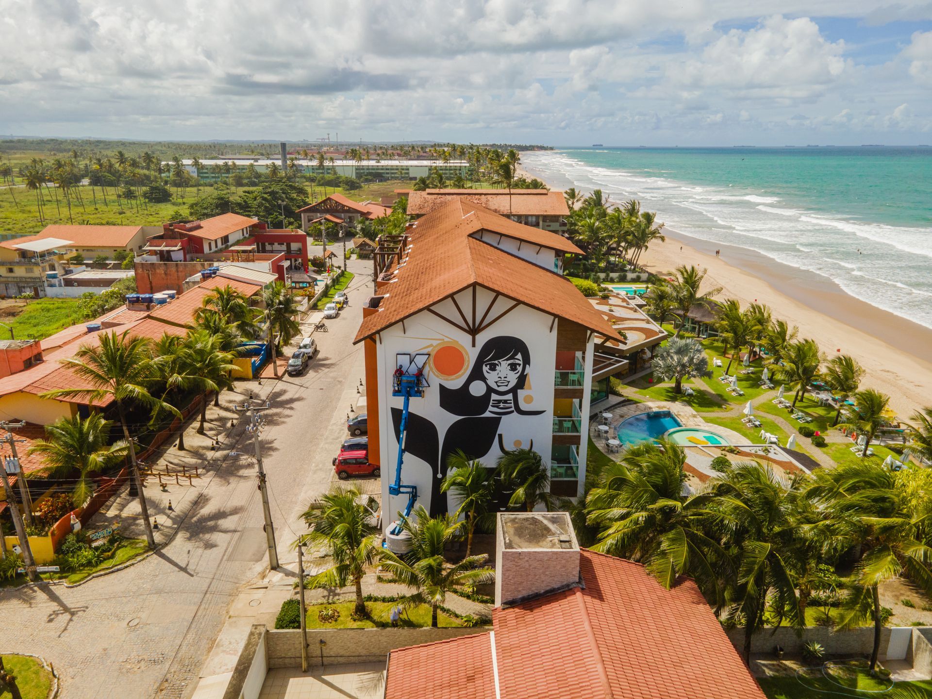 Vista aérea do hotel  beira-mar em Porto de Galinhas, com piscina, coqueiros e acesso direto à praia