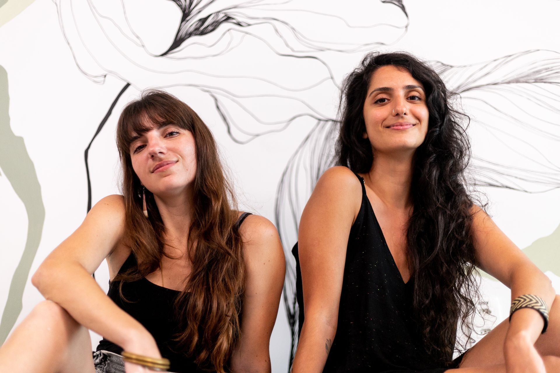 Juliana Nersessian e Carolina Barbosa com o mural no apartamento 111 do hotel.