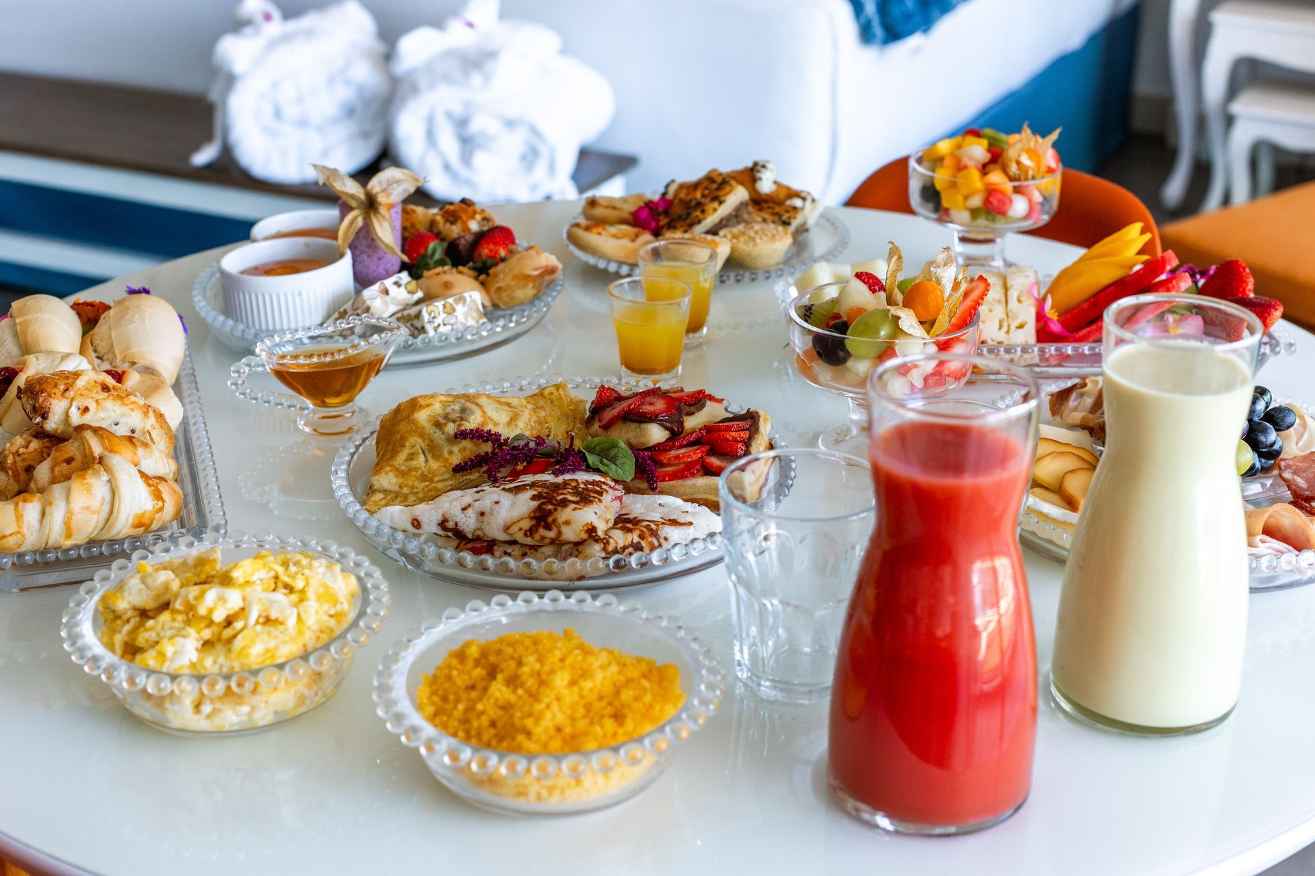 Mesa de café da manhã elaborada no Kembali com pães frescos, ovos mexidos, frutas variadas, sucos naturais & mel.