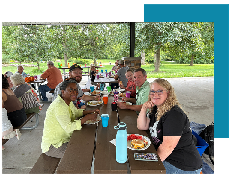 Several Church Members From Fairview Church of Christ at a Picnic Table Smiling. Find Community!