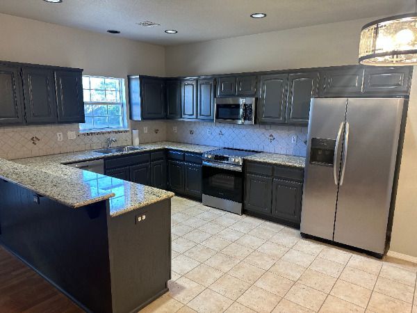 A kitchen with stainless steel appliances and granite counter tops.