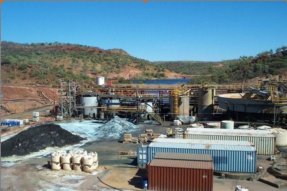 A large industrial area with a lot of buildings and mountains in the background.