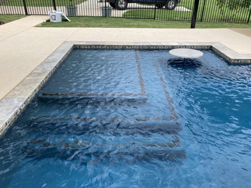 Backyard swimming pool with blue water, steps, and a circular float near the edge
