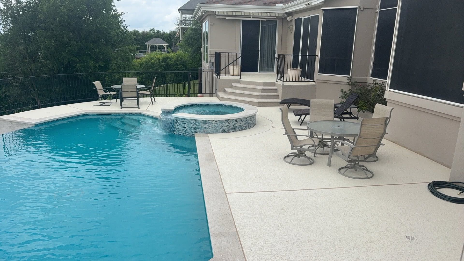 Backyard pool with hot tub, patio chairs, and a covered outdoor seating area