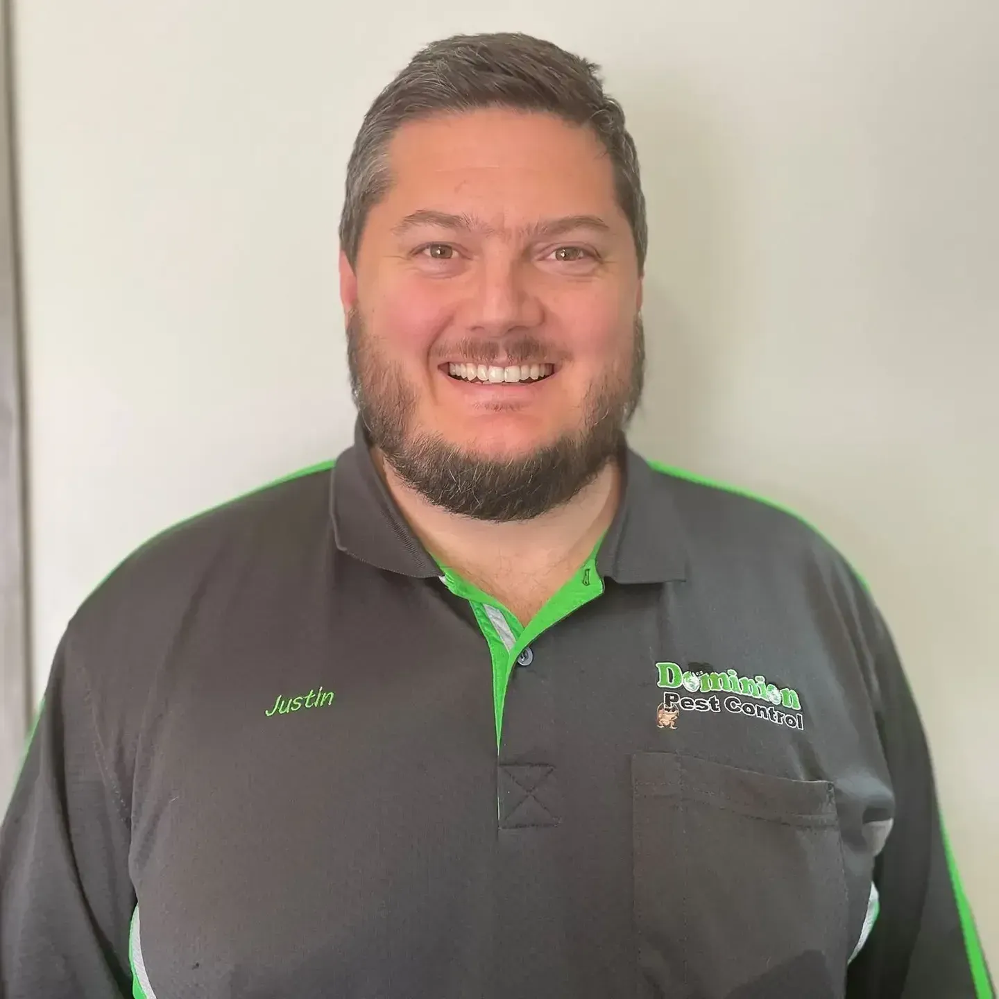 Justin in a black and green polo shirt, smiling — Dominion Pest Control in Kingaroy, QLD