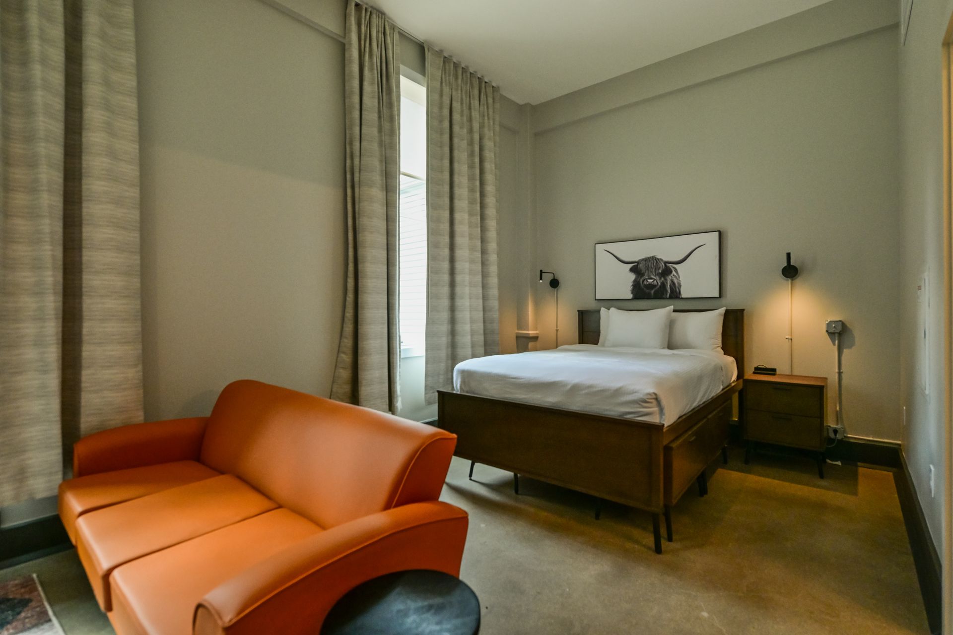 A hotel room with a large bed , desk , chair and balcony.