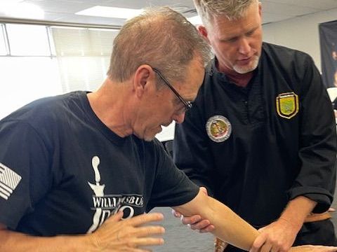 Two men are standing next to each other and one of them is holding another man 's arm.