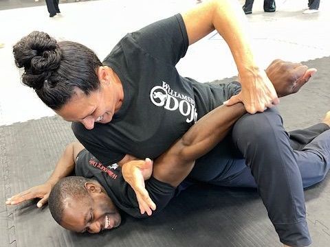 A man and a woman are wrestling on a mat.