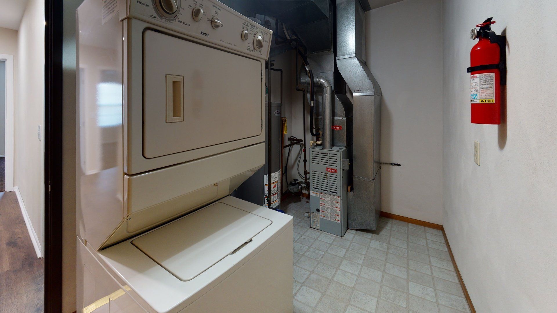 A washer and dryer are stacked on top of each other in a laundry room.