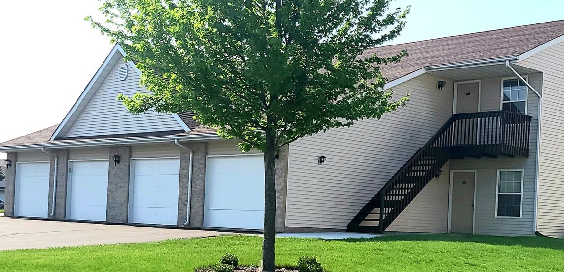 A house with stairs and a tree in front of it