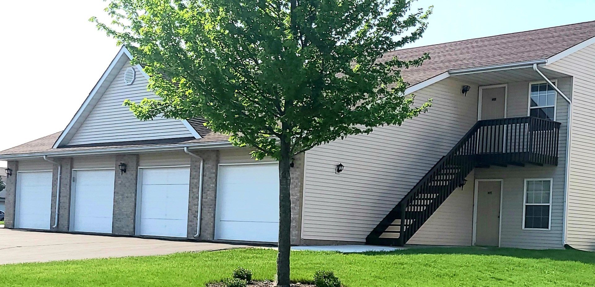 A house with stairs and a tree in front of it