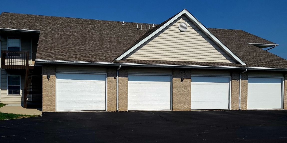 A house with a lot of garage doors and a balcony