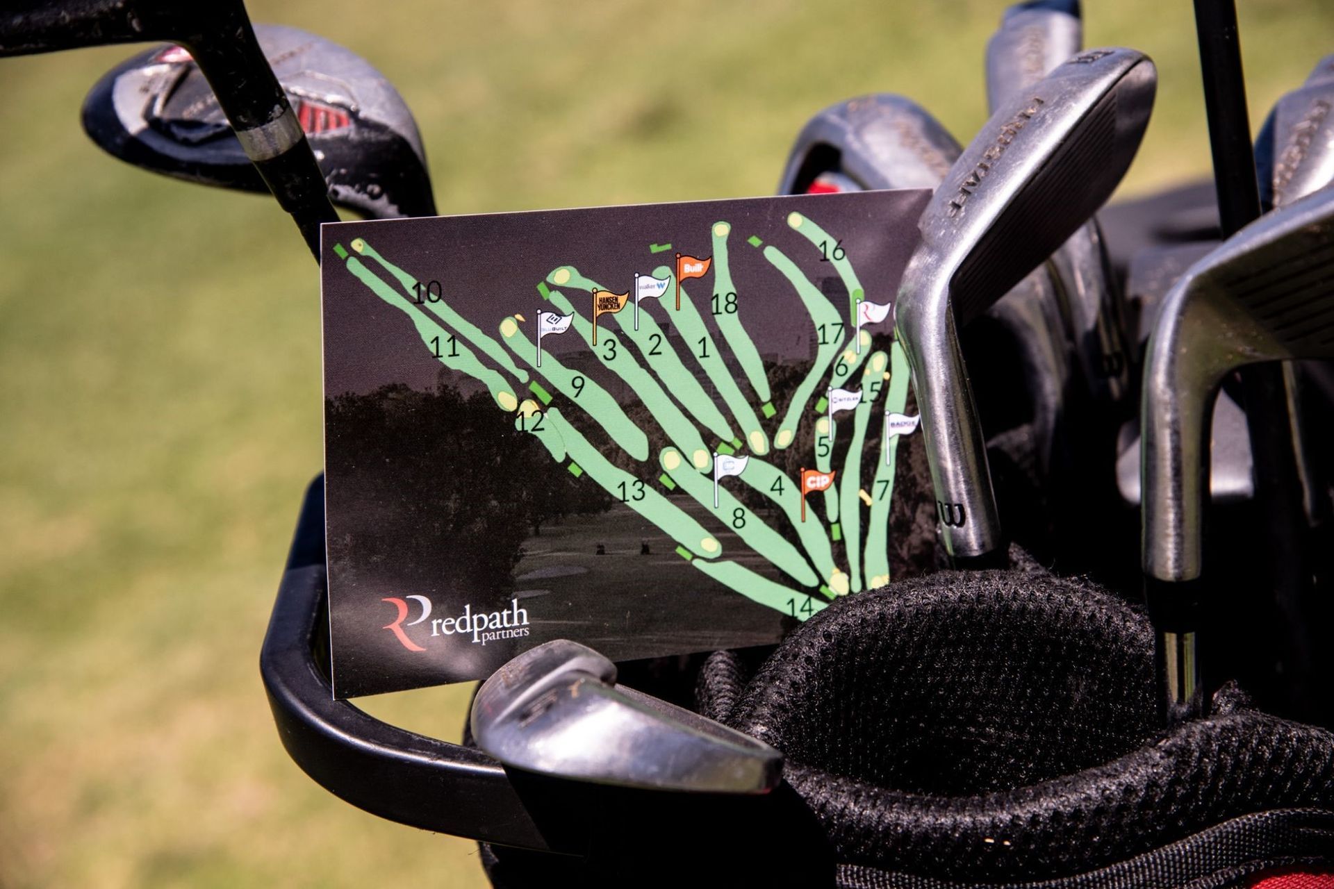 A golf bag containing clubs and a course map card showing hole layouts.