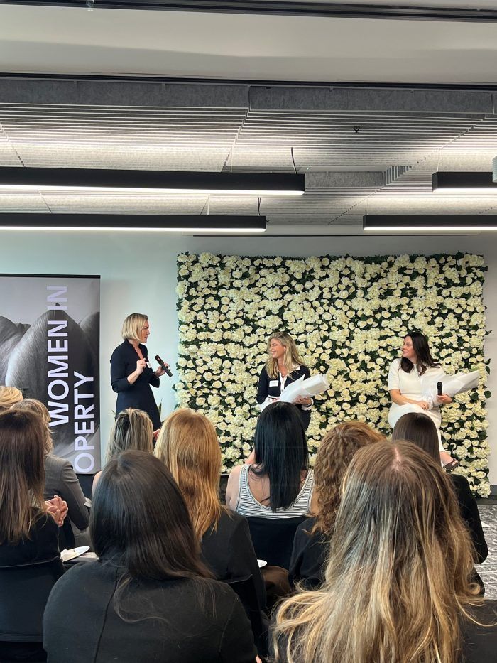 A panel of three people speaks at a 