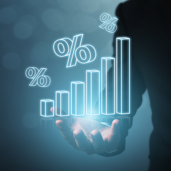 A business person’s hand holds a glowing holographic bar chart with percentage symbols rising in height.