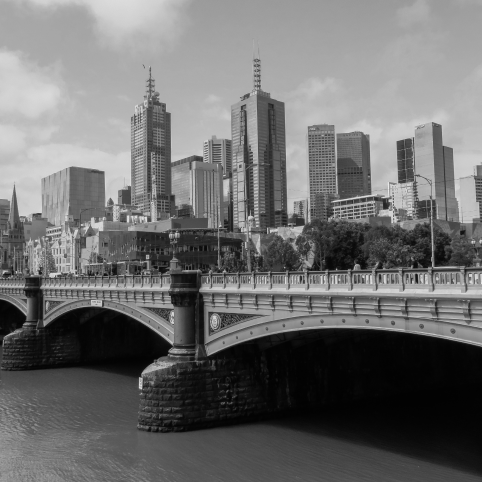The Princes Bridge spans the Yarra River in front of the Melbourne city skyline, featuring arched stone piers.