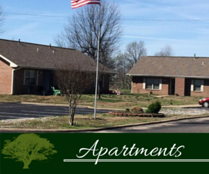 Apartment buildings with a U.S. flag and green sign reading “Apartments”