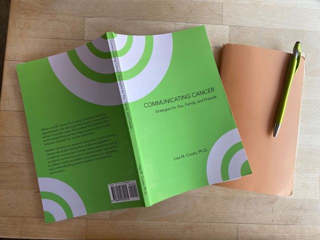 Communicating Cancer book flat-lay on wooden surface
