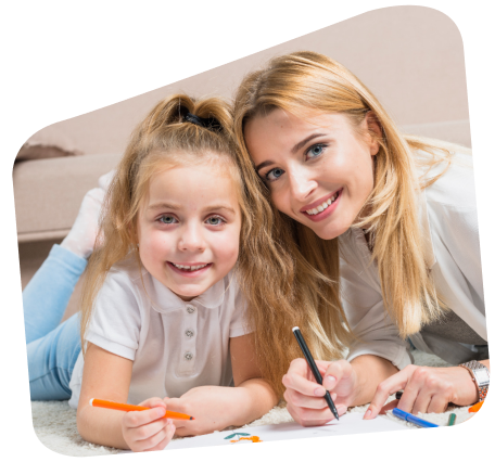 Woman and child smiling, drawing on paper together.