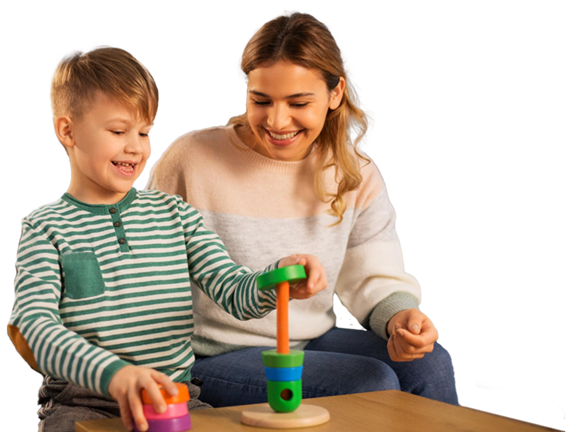 A child and adult playing with a stacking toy at a table; they are smiling.